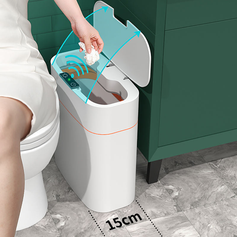 A white smart trash can with a hinged lid is shown next to a toilet in a bathroom setting. A hand is placing a tissue into the open bin, with blue graphic arrows indicating the lid opening motion and a '15cm' size marker on the floor showing the bin's width.