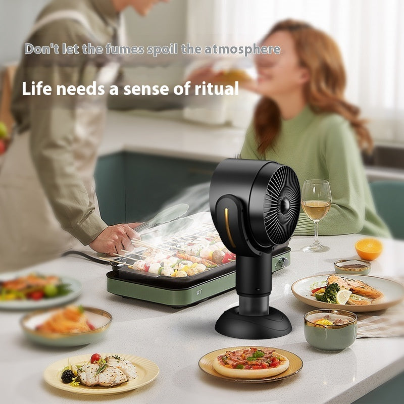 Black portable fan on a dining table with people and food in the background