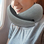 Girl using a gray travel neck pillow on a plane