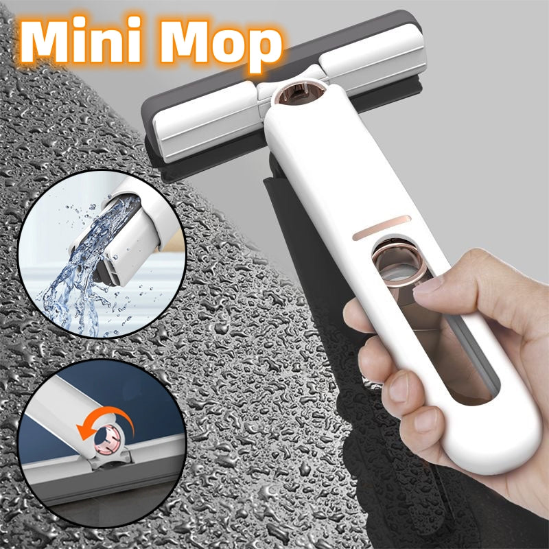 Mini mop being used on a textured surface with water splashes and a hand holding the mop.