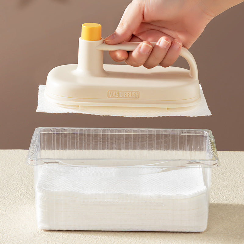 Hand using a Magic Brush cleaning tool over a container with a beige background